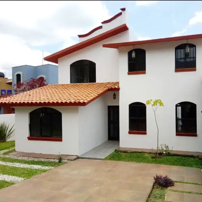Exterior two story white country house home for sale real estate with parking, gardens, Spanish tile roof, and grass lawn in San Andrés Huayapam, Oaxaca, Mexico