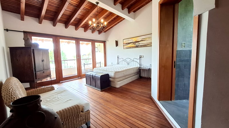 Bedroom 1 suite with exposed wooden beams and terrace access — Mediterranean villa for sale, Oaxaca
