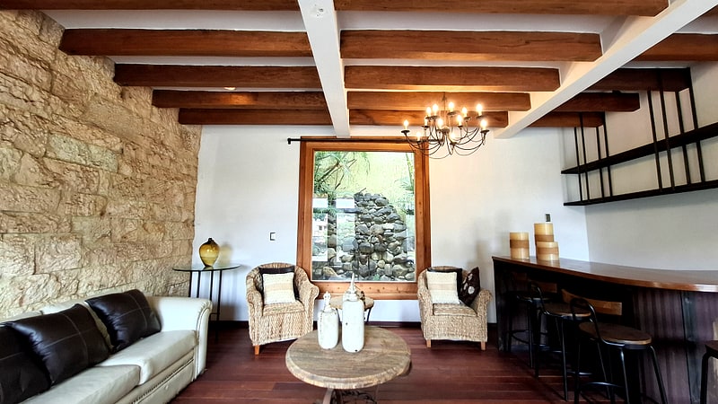 Living room picture window looking onto the rock garden and fish pond — Mediterranean home in Oaxaca