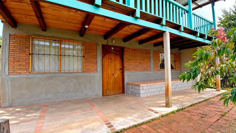 Timber front door and entrance porch of the main house, two house mountain property for sale in San Mateo Río Hondo, Sierra Madre del Sur, Oaxaca