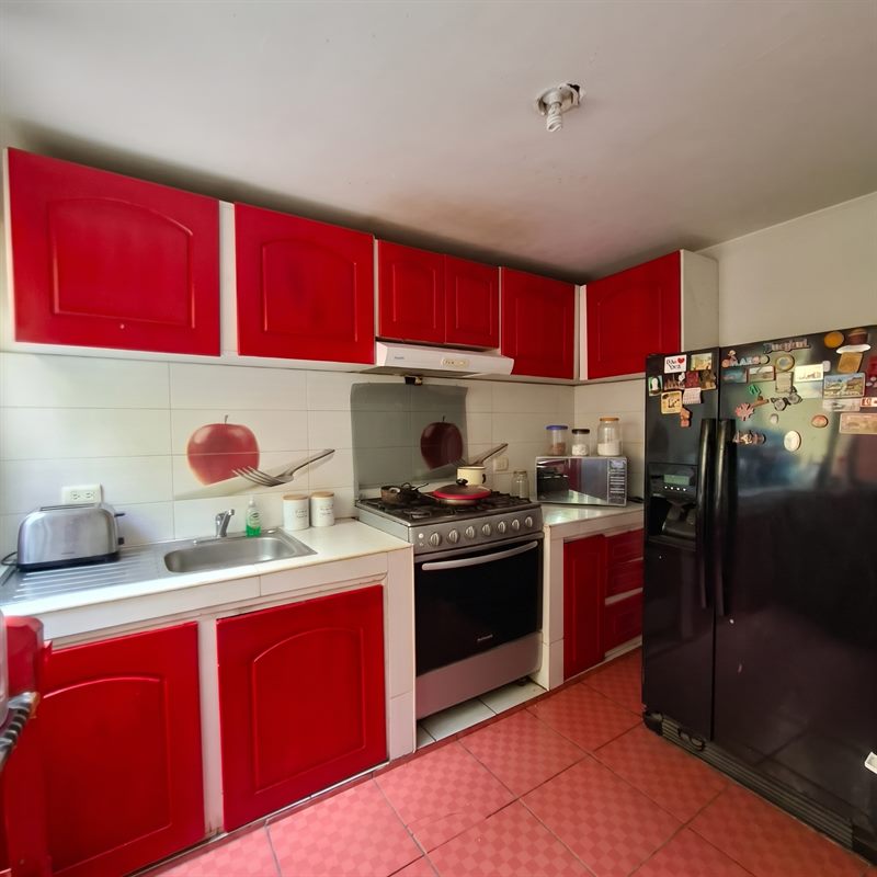 Kitchen with red cabinetry, gas range and tiled backsplash in this casa en venta south of Oaxaca city, Mexico