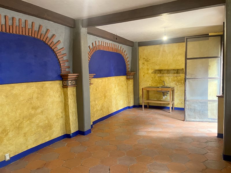 Ground floor rental apartment interior with terracotta hexagonal floor tile and blue arch detail, Oaxaca