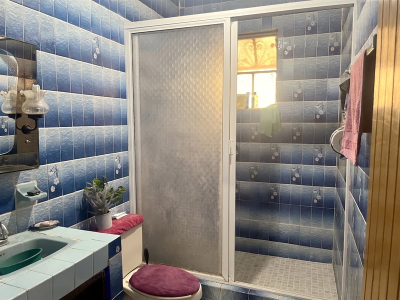 Tiled full bathroom with vanity and shower enclosure in the main house of this El Tule real estate listing