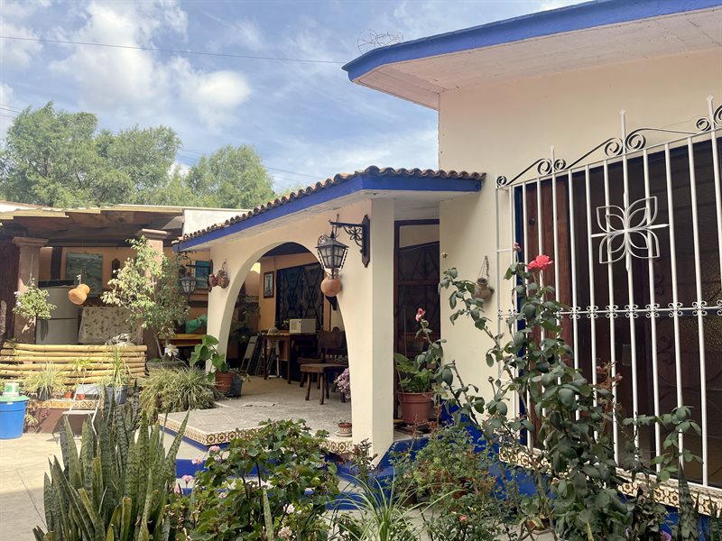 Single floor main house with tiled roof and arched front porch seen from the front patio in Santa Maria del Tule, Oaxaca
