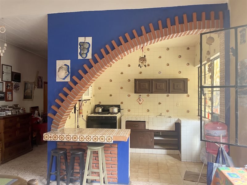 Kitchen under a brick arch with breakfast bar and stools inside the main house, Santa Maria del Tule Oaxaca