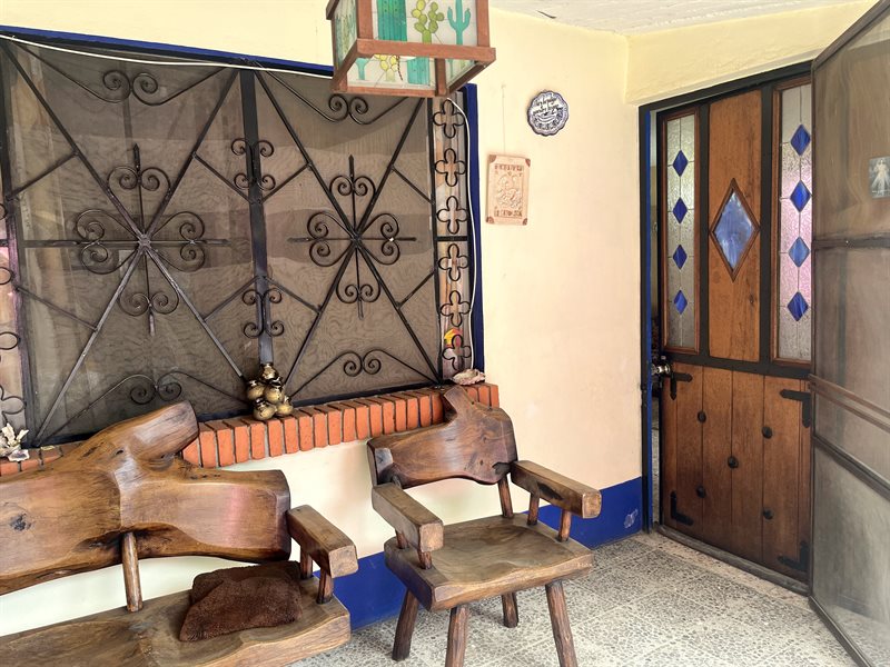Very large covered front porch with seating and hanging lantern on a Oaxaca home with rental units for sale