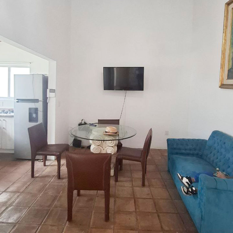 Oaxaca city house for rent living room with high ceilings, wooden beams, and suspended lighting fixture